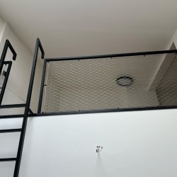 Moderné kovové zábradlie s nerezovou sieťou a rebríkom